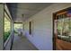 Covered porch with wood flooring and railing overlooking a tranquil wooded area and porch swing at 5534 Blackhawk Dr, Acworth, GA 30102