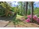 Well maintained lawn featuring green grass, tall trees, and a garden of pink flowers at 5534 Blackhawk Dr, Acworth, GA 30102