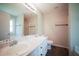 Bright bathroom featuring double sinks, modern fixtures, wood floors, and a shower with a glass door at 660 Allens Landing Dr, Lawrenceville, GA 30045