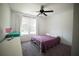 Cozy bedroom featuring a ceiling fan, window with natural light, and a bed with purple coverlet at 660 Allens Landing Dr, Lawrenceville, GA 30045