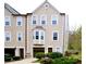 Charming exterior of a tan two-story townhome featuring a bay window and a one car garage at 988 Vintage Pointe Dr, Lawrenceville, GA 30044