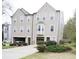 Exterior view of townhomes with driveways, garages and manicured landscaping at 988 Vintage Pointe Dr, Lawrenceville, GA 30044