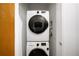 A stacked white Samsung washer and dryer sit in a closet with a louvered shelf at 130 Arizona Ne Ave # 214, Atlanta, GA 30307
