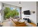Living room with wall-to-wall window overlooking the balcony and tree lined view, leather sofa at 130 Arizona Ne Ave # 214, Atlanta, GA 30307