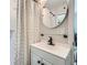 The bathroom offers a sleek sink, vanity, an oval mirror, and a shower with a patterned curtain at 1461 Sanden Ferry Dr, Decatur, GA 30033