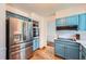 An open kitchen with painted cabinets, stainless steel appliances, white countertops and hardwood floors at 1461 Sanden Ferry Dr, Decatur, GA 30033