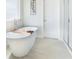 Bright bathroom featuring a modern soaking tub, light tile floors and elegant fixtures at 149 Weldon Rd, Mcdonough, GA 30253