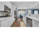 Modern kitchen with white cabinets, stainless steel appliances, stone countertops, and hardwood floors at 1549 Tappahannock Trl, Marietta, GA 30062