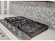 This gourmet kitchen features a modern gas stove and sleek herringbone backsplash, perfect for cooking enthusiasts at 1549 Tappahannock Trl, Marietta, GA 30062