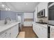 Modern kitchen with white cabinets, stainless steel appliances, stone countertops, and hardwood floors at 1549 Tappahannock Trl, Marietta, GA 30062