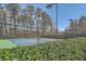 Tennis courts surrounded by a chain link fence and trees, showing lush landscaping at 1549 Tappahannock Trl, Marietta, GA 30062
