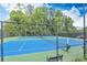 A tennis court with a new, blue and green surface surrounded by a chain link fence and trees at 1549 Tappahannock Trl, Marietta, GA 30062