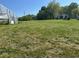 Vast grass-covered land with a greenhouse and small building in the background at 2085 Jones Phillips Rd, Dacula, GA 30019