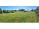 Expansive grassy lot perfect for development or recreation, bordered by mature trees and a greenhouse at 2085 Jones Phillips Rd, Dacula, GA 30019