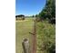 Picturesque grassy area with vintage fence, an outdoor structure, and mature trees, blending nature and history at 2085 Jones Phillips Rd, Dacula, GA 30019