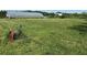 Expansive grassy area with a greenhouse, hose, and faucet ready for development at 2085 Jones Phillips Rd, Dacula, GA 30019