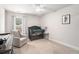 Charming bedroom features soft carpeting, a large window, a crib, and a cozy rocking chair at 214 Gaston Ct, Canton, GA 30115