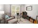 Bright bedroom with neutral walls, a comfortable armchair, musical instruments, and a large window at 214 Gaston Ct, Canton, GA 30115