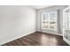 This light-filled bedroom features sleek hardwood floors, a large window, and a stylish glass door at 214 Gaston Ct, Canton, GA 30115