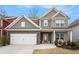 Beautiful two-story home featuring stone accents, a two-car garage, and a charming front porch swing at 214 Gaston Ct, Canton, GA 30115