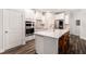 Modern kitchen featuring white cabinets, stainless steel appliances, an island with seating, and hardwood floors at 214 Gaston Ct, Canton, GA 30115