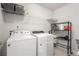Bright laundry room features a full-size washer and dryer, storage shelves, and a convenient rolling storage cart at 214 Gaston Ct, Canton, GA 30115