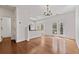 Bright dining area with hardwood floors, chandelier, and french doors to a deck adjacent to the breakfast bar and kitchen at 3972 Church View Ln, Suwanee, GA 30024