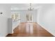 Open-concept dining room featuring hardwood floors, a stylish chandelier, and access to the outdoor deck through french doors at 3972 Church View Ln, Suwanee, GA 30024