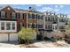 A row of townhomes featuring mixed brick and siding exteriors, garages and nicely maintained landscaping at 3972 Church View Ln, Suwanee, GA 30024