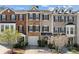 Charming townhome exterior featuring a mix of brick and stone facade, well-maintained landscaping, and attached garages at 3972 Church View Ln, Suwanee, GA 30024