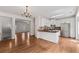 Well-lit kitchen with stainless steel appliances, dark countertops, white cabinets, and hardwood floors adjacent to the living room at 3972 Church View Ln, Suwanee, GA 30024