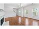 Sunlit living room with hardwood floors, white trim and fireplace adjacent to the staircase at 3972 Church View Ln, Suwanee, GA 30024
