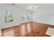 Bright living room with hardwood floors, large windows, and elegant trim, adjacent to the fireplace at 3972 Church View Ln, Suwanee, GA 30024