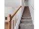 Carpeted staircase featuring a white bannister and a wooden handrail at 3972 Church View Ln, Suwanee, GA 30024