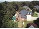 Aerial view of the house highlighting backyard pool, patio area, and treed property at 2165 Sugarstone Ct, Lawrenceville, GA 30043
