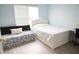 Bright bedroom with blue walls, a bed, futon, and window with natural light at 2165 Sugarstone Ct, Lawrenceville, GA 30043