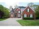 Traditional brick home with manicured lawn, dark shutters, and a large driveway, offering classic curb appeal at 2165 Sugarstone Ct, Lawrenceville, GA 30043