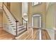 Light and airy foyer featuring hardwood floors, a staircase, and an arched doorway at 2165 Sugarstone Ct, Lawrenceville, GA 30043