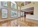 Spacious living area featuring large windows, hardwood floors and adjacent kitchen area, offering an open and bright living space at 2165 Sugarstone Ct, Lawrenceville, GA 30043