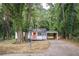 Charming single-story home with covered parking and a welcoming orange front door nestled among mature trees at 2437 Clarissa Nw Dr, Atlanta, GA 30318