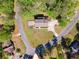 Overhead shot of a brick residence nestled among trees, featuring an expansive lawn and a quiet street at 244 Saint Patrick Sw Dr, Mableton, GA 30126