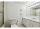Well-lit bathroom featuring a toilet, vanity with sink, and storage cabinets at 244 Saint Patrick Sw Dr, Mableton, GA 30126