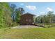 Rear exterior view of a brick house with spacious yard and back porch at 244 Saint Patrick Sw Dr, Mableton, GA 30126