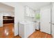 Bright laundry room with modern washer, dryer, cabinets, and a utility sink at 244 Saint Patrick Sw Dr, Mableton, GA 30126