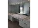 Bathroom features a large, frameless mirror above a double sink vanity, tub is in the background at 3657 Clearbrooke Ct, Duluth, GA 30097
