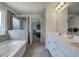 Primary bathroom featuring dual vanities, soaking tub, glass enclosed shower, and access to the main bedroom at 419 Murphy Ave, Canton, GA 30114