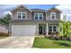 Charming two-story home featuring a two car garage and a welcoming front porch, set against a bright, cloudy sky at 419 Murphy Ave, Canton, GA 30114