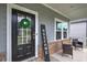 Close-up of a welcoming front door adorned with a wreath, complemented by stylish seating on the porch at 419 Murphy Ave, Canton, GA 30114