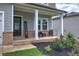 Inviting front porch with brick accents and cozy seating, complemented by manicured landscaping at 419 Murphy Ave, Canton, GA 30114