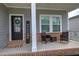 A welcoming front porch with stylish seating, brick accents, and a 